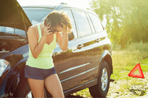 Top Summer Car Care Tips from Your Team at CAMS Automotive; image of female in shorts and tank top in summer heat leaned up against her black suv is broke down on side of road with hood of car open talking on the phone with hand on her forehead