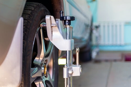 Wheel Alignments by CAM Automotive in Kenner, LA. Closeup image of a car with sensors on wheels for wheel alignment.