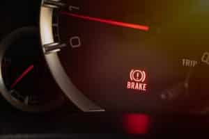 How To Tell When Your Brakes Are About to Break - Before It’s Too Late | CAMS Automotive in Kenner, LA. Closeup image of a brake warning light in a car’s dashboard.