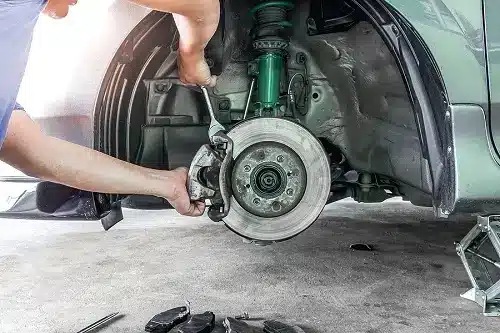 To DIY or Not to DIY: Brake Repair at Home | CAMS Automotive in Kenner, LA. Image of a man repairing his car’s brake system at his home garage.