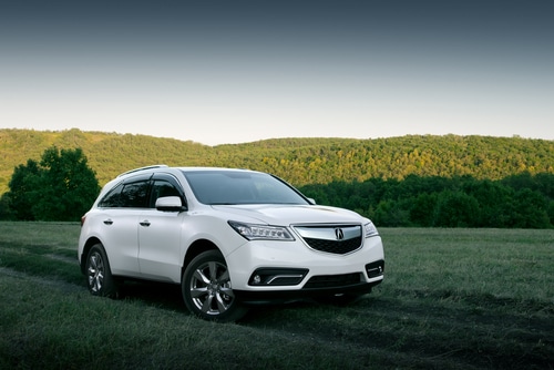 Acura repair and maintenance services in Kenner, LA. at CAMS Automotive. Image of white Acura MDX SUV driving on a mountain road.