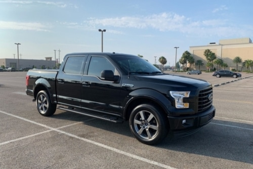 Expert Ford repair and maintenance services in Kenner, LA at CAMS Automotive. Image of black ford f 150 pickup truck parked in mall parking lot.