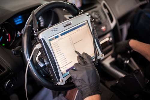 Vehicle Diagnostic and Repairs in Kenner, LA at CAMS Automotive. Image of a car mechanic performing automobile computer diagnosis for engine failure using diagnostic equipment in a vehicle.