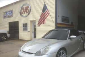 Full-service auto shop in Kenner, LA at CAMS Automotive. Image of a silver Porsche parked in front of the shop, showcasing the company’s dedication to restoring vehicles to peak condition with precision and care.