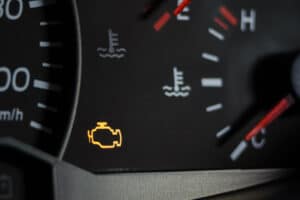 Check engine light, auto repair in Kenner, LA by CAMS Automotive. Image of a check engine light alongside temperature gauges, signaling the need for professional vehicle evaluation.